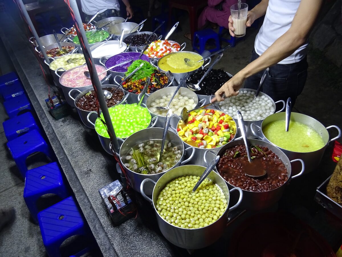 A street stall with pots of colored jellies, beans and toppings for sweet che desserts