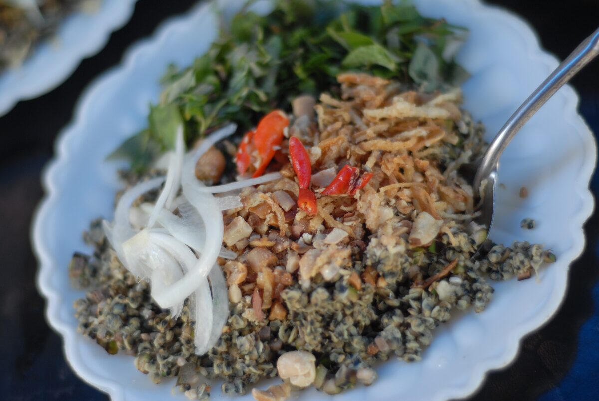 A plate of small Hue clams mixed with sliced onion, chili, fried shallots and herbs