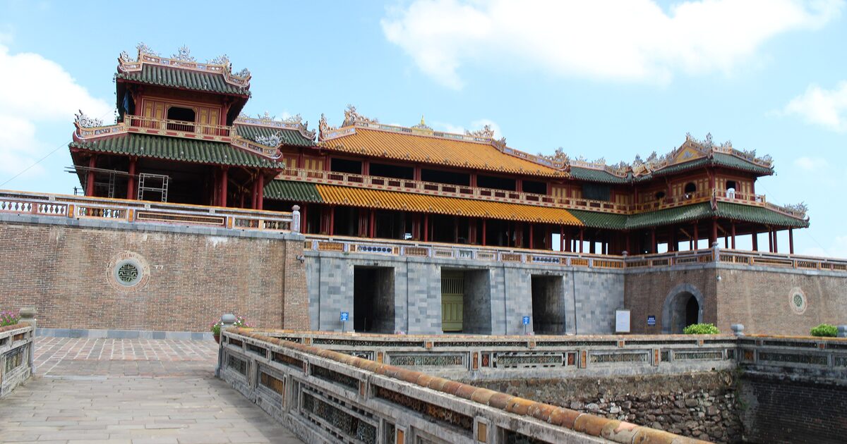 The Ngo Mon Gate of the Hue Imperial City under a blue sky, its yellow-roofed pavilion above the main gate