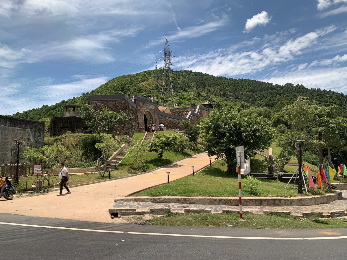 The Hai Van Gate fortress on the green hilltop above the Hai Van Pass road, under a blue sky