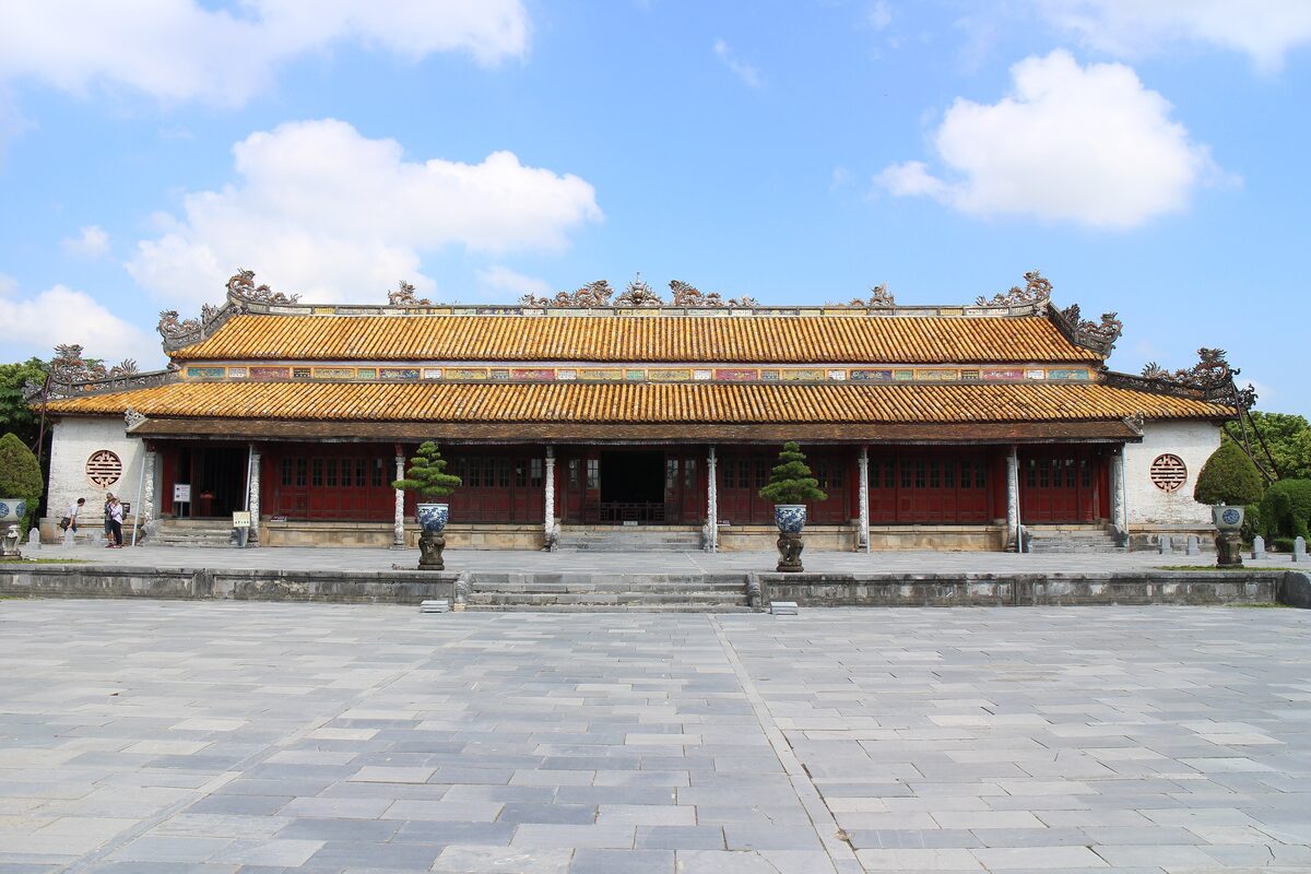 The Thai Hoa Palace throne hall with its yellow-tiled roof across an empty stone courtyard