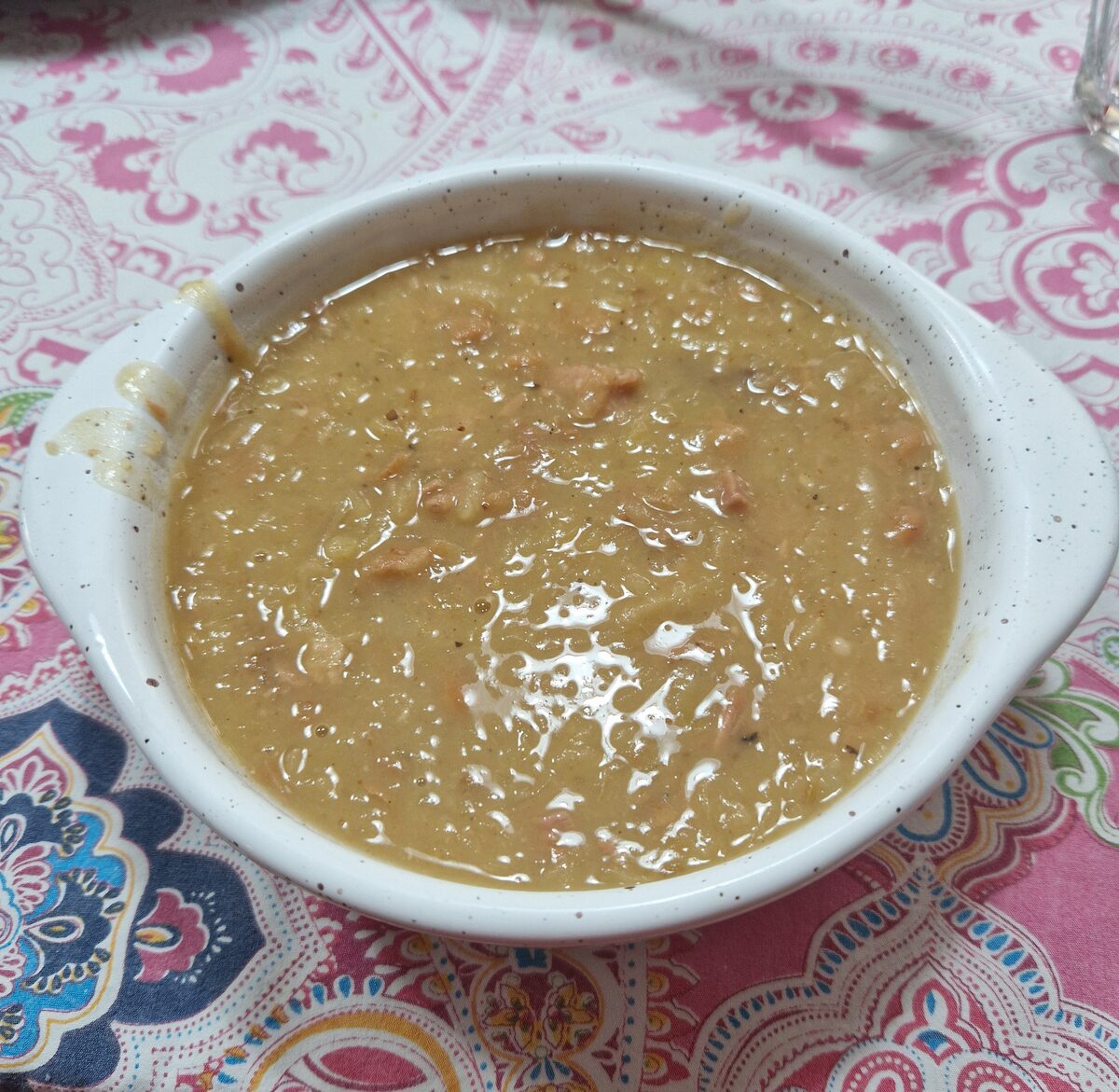 A bowl of jota, the thick Slovenian bean soup, on a patterned cloth