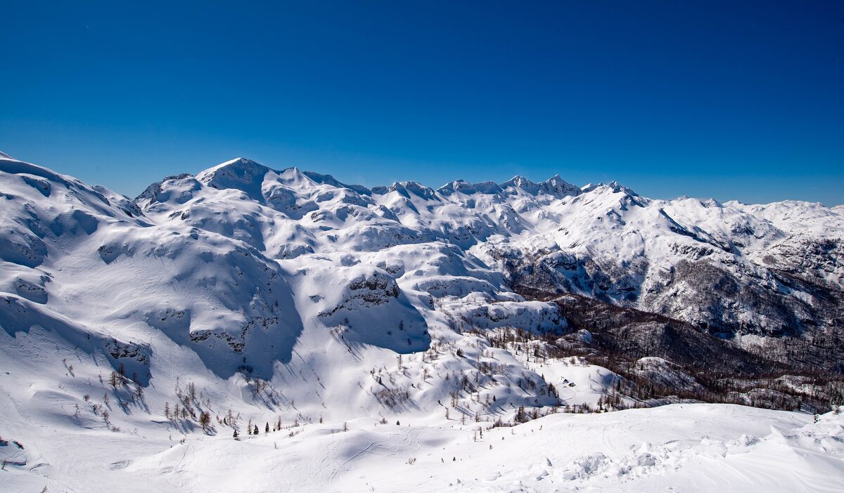 Snow-covered Julian Alps seen from the top of Vogel under a deep blue winter sky, the view the cable car brings you to