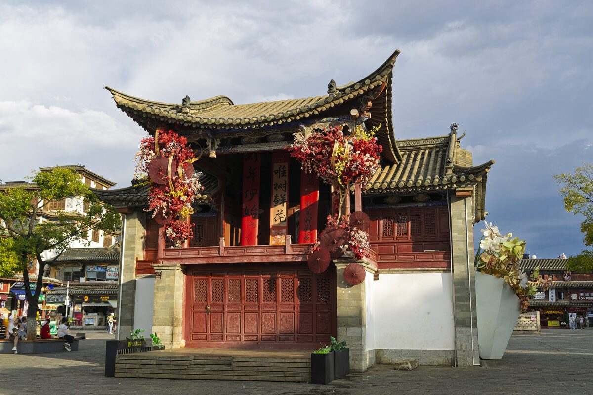 The old wooden opera stage in Guandu Ancient Town, decked with flowers beside the square