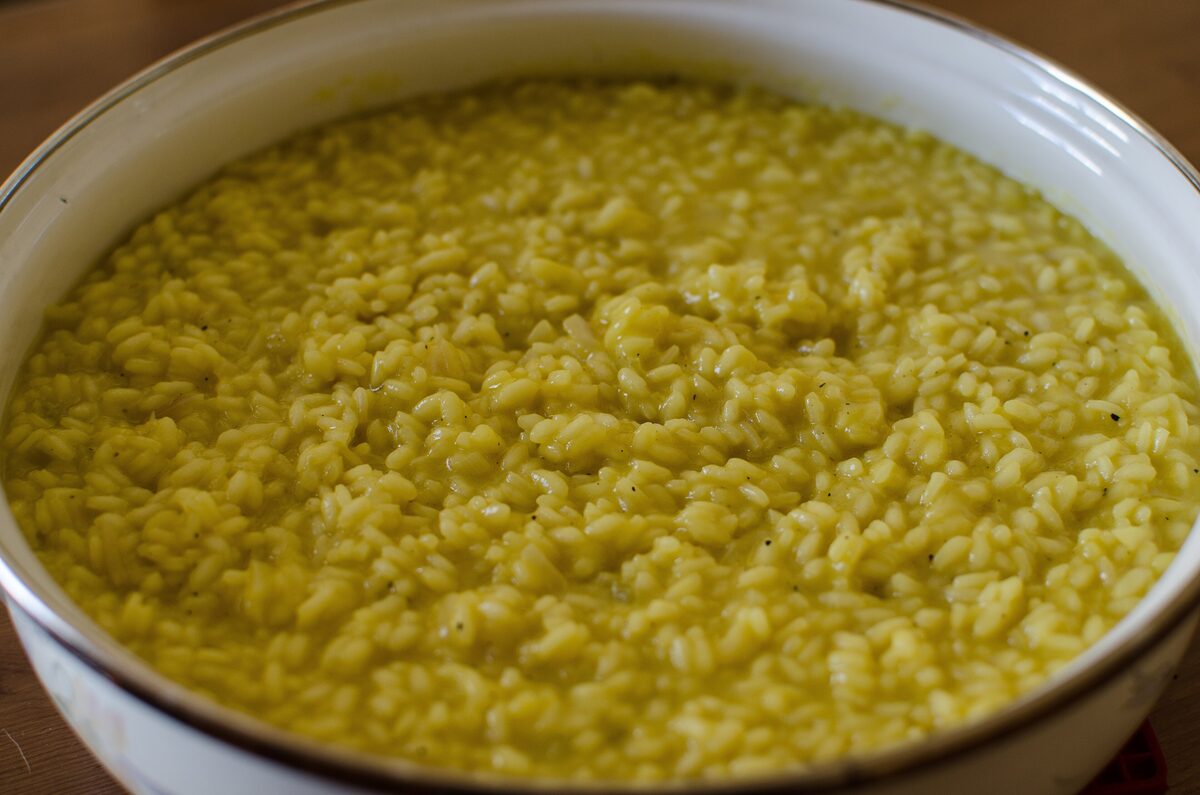 Saffron risotto, the classic Milanese yellow, in a white bowl