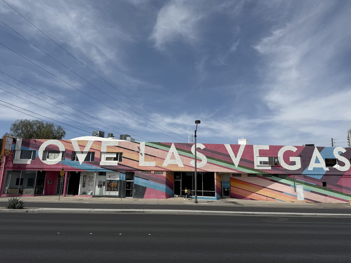 A low building in the 18b Arts District painted with colorful stripes and a large Love Las Vegas sign