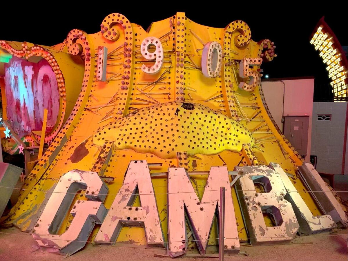 The restored Golden Nugget Gambler sign with its yellow curved top and 1905 lettering in the Neon Museum boneyard