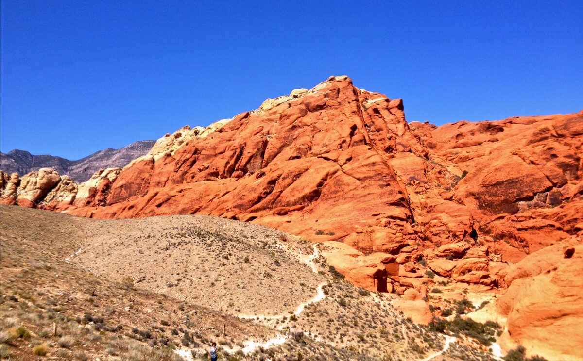 Red and orange sandstone cliffs of the Calico Hills in Red Rock Canyon under a blue sky