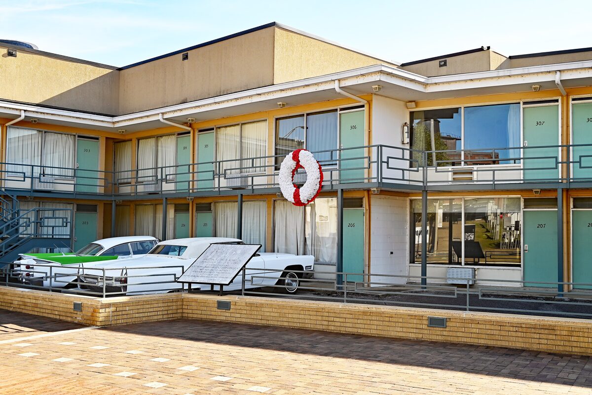 The Lorraine Motel balcony and two vintage cars at the Civil Rights Museum