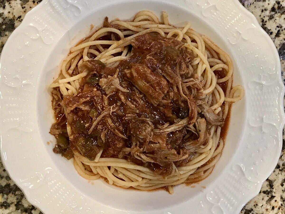 A plate of barbecue spaghetti with chopped pork in sauce