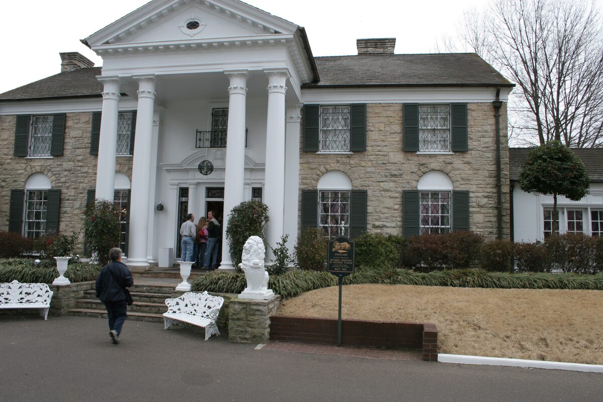 Graceland's white-columned front and stone facade, with visitors at the door