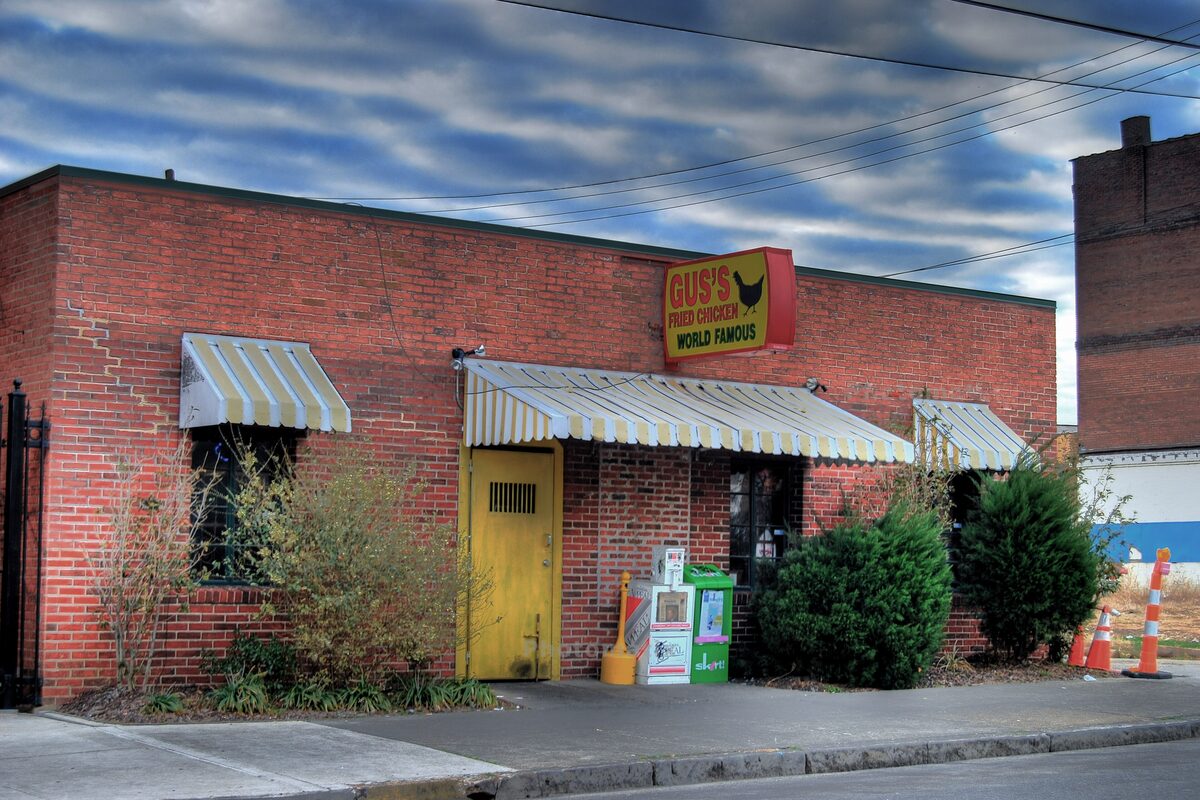 Gus's, a low brick building with striped awnings and a yellow door