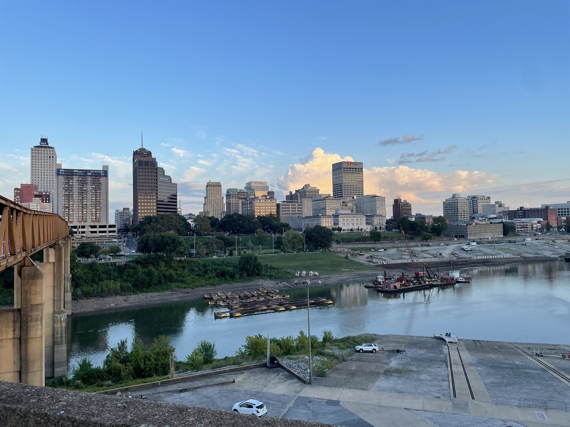 Downtown Memphis skyline above the Mississippi, seen past a rust-colored bridge