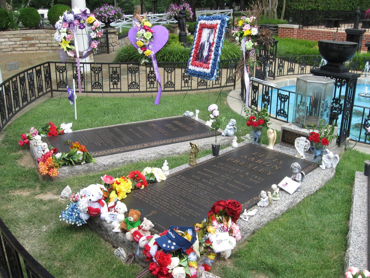 Elvis's grave in the Meditation Garden, covered in flowers and toys