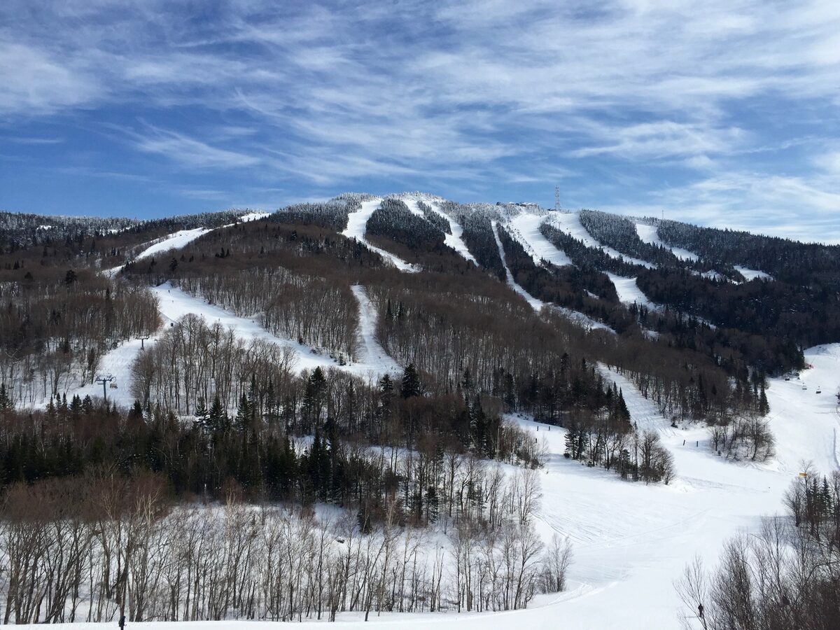 Snow-covered ski trails cutting through the forest on the south face of Mont Tremblant in winter