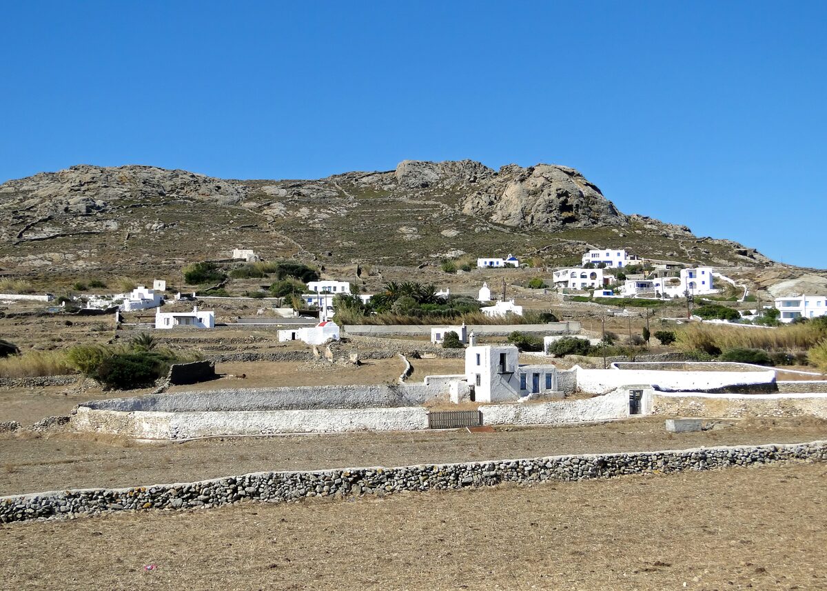 The village of Ano Mera, white houses on a dry hillside above the monastery walls
