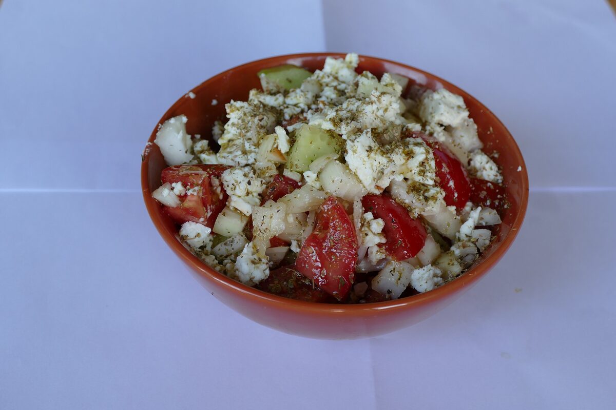 Greek salad in a small bowl with tomato, cucumber and crumbled feta