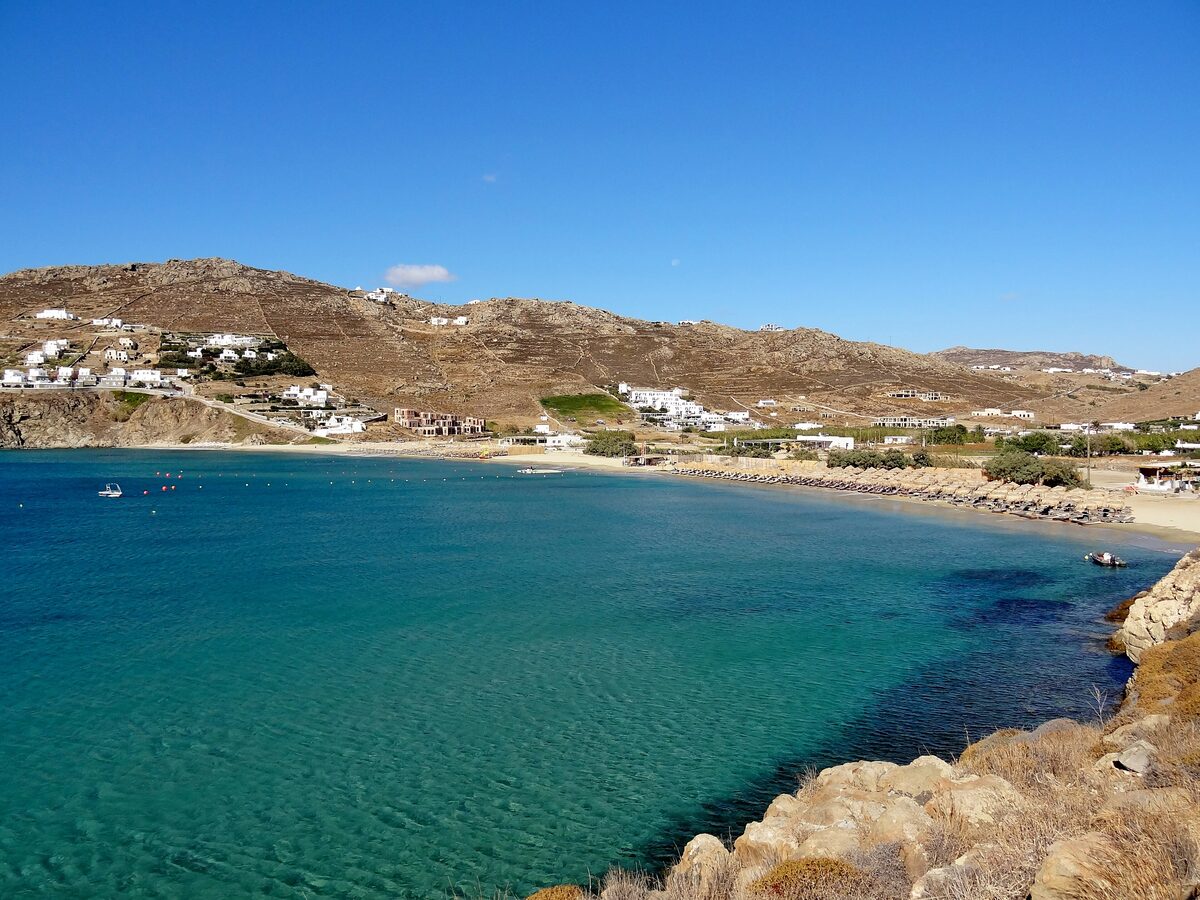 Kalo Livadi beach, a wide bay of clear turquoise water backed by dry hills