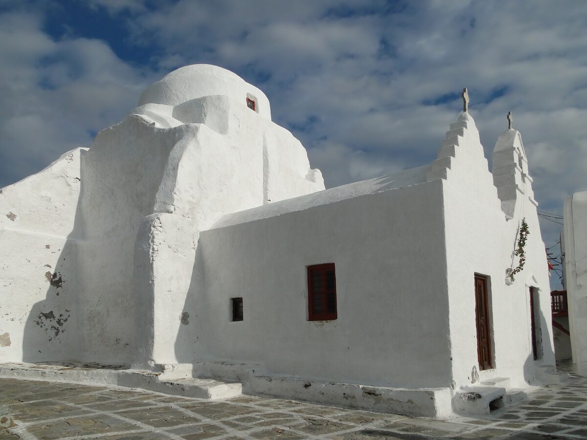 Panagia Paraportiani with its whitewashed domes and walls against a blue sky