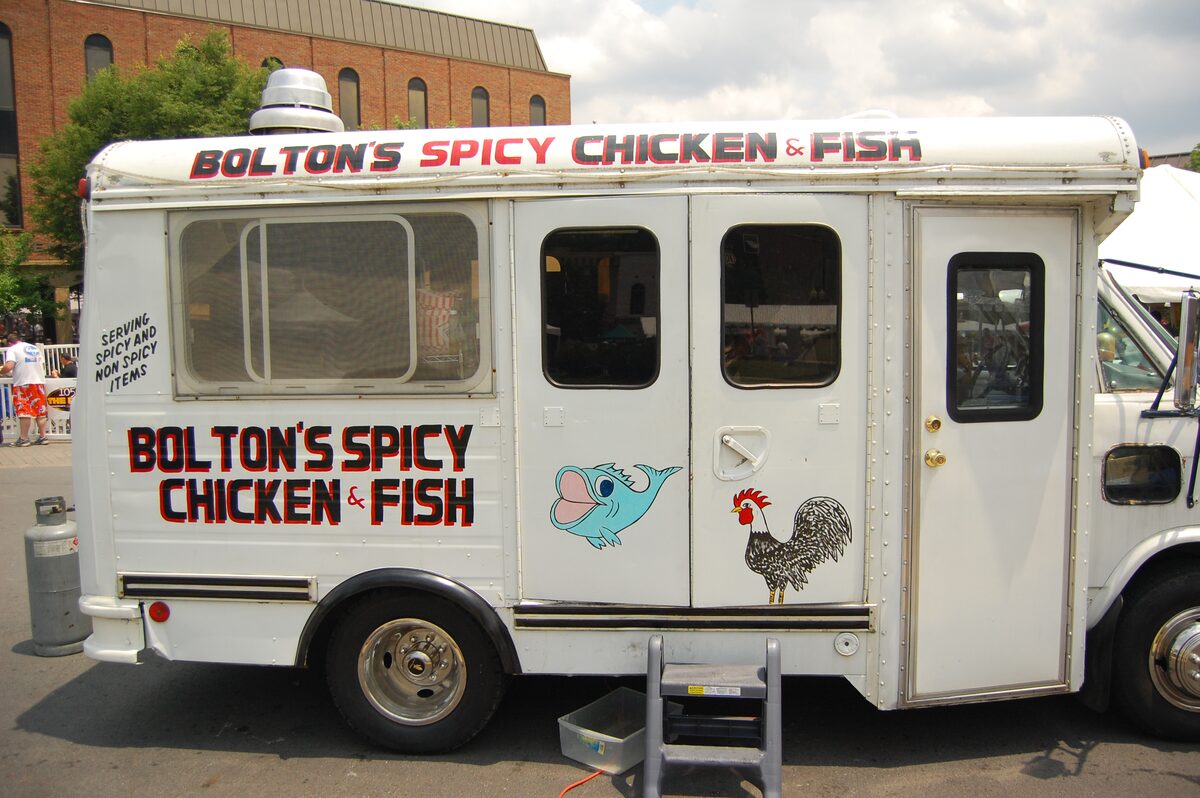 The white Bolton's Spicy Chicken and Fish food truck with its painted rooster and lettering