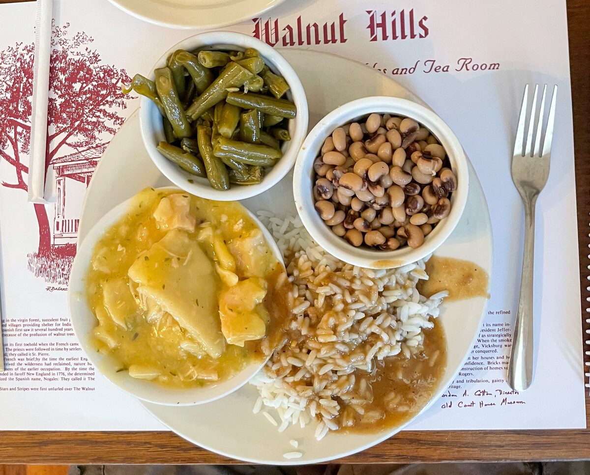 A meat-and-three plate of chicken and dumplings with green beans, rice and black-eyed peas