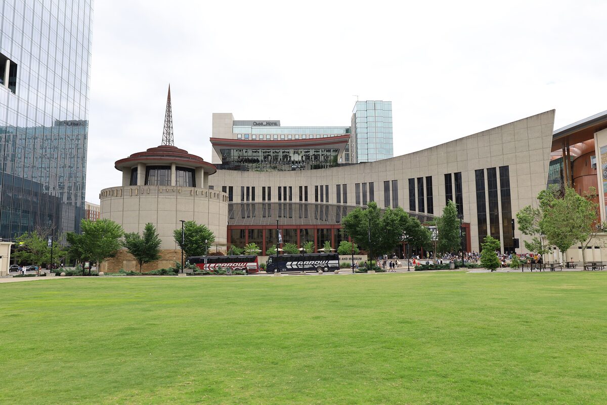 The Country Music Hall of Fame and Museum building with its curved facade and tower seen across a lawn