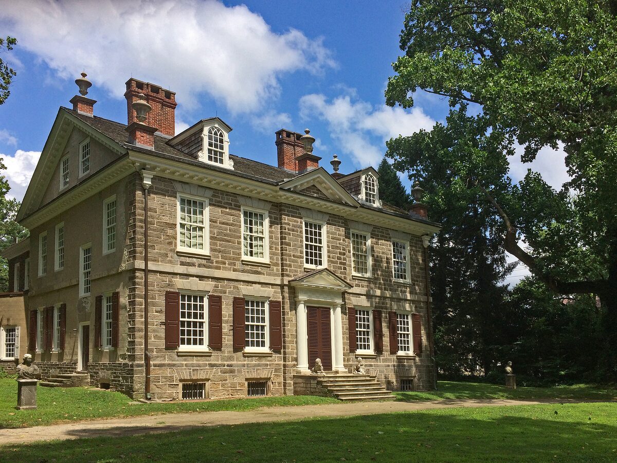 The stone Georgian mansion of Cliveden behind a green lawn in Germantown