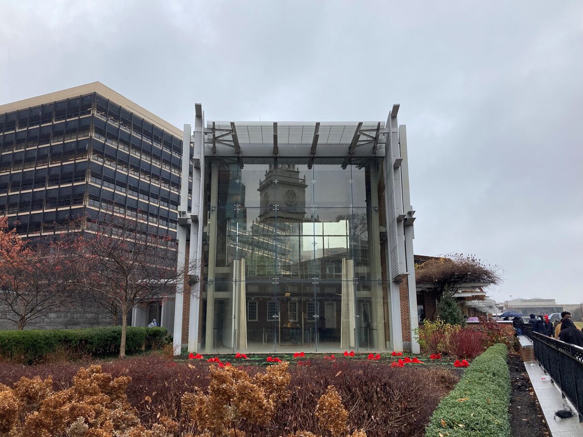 The glass-fronted Liberty Bell Center with Independence Hall's tower reflected in it