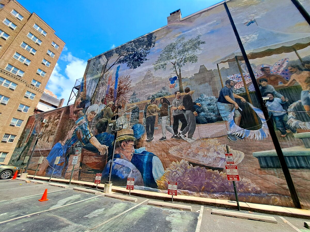 A huge painted mural of figures at work covering the side of a building