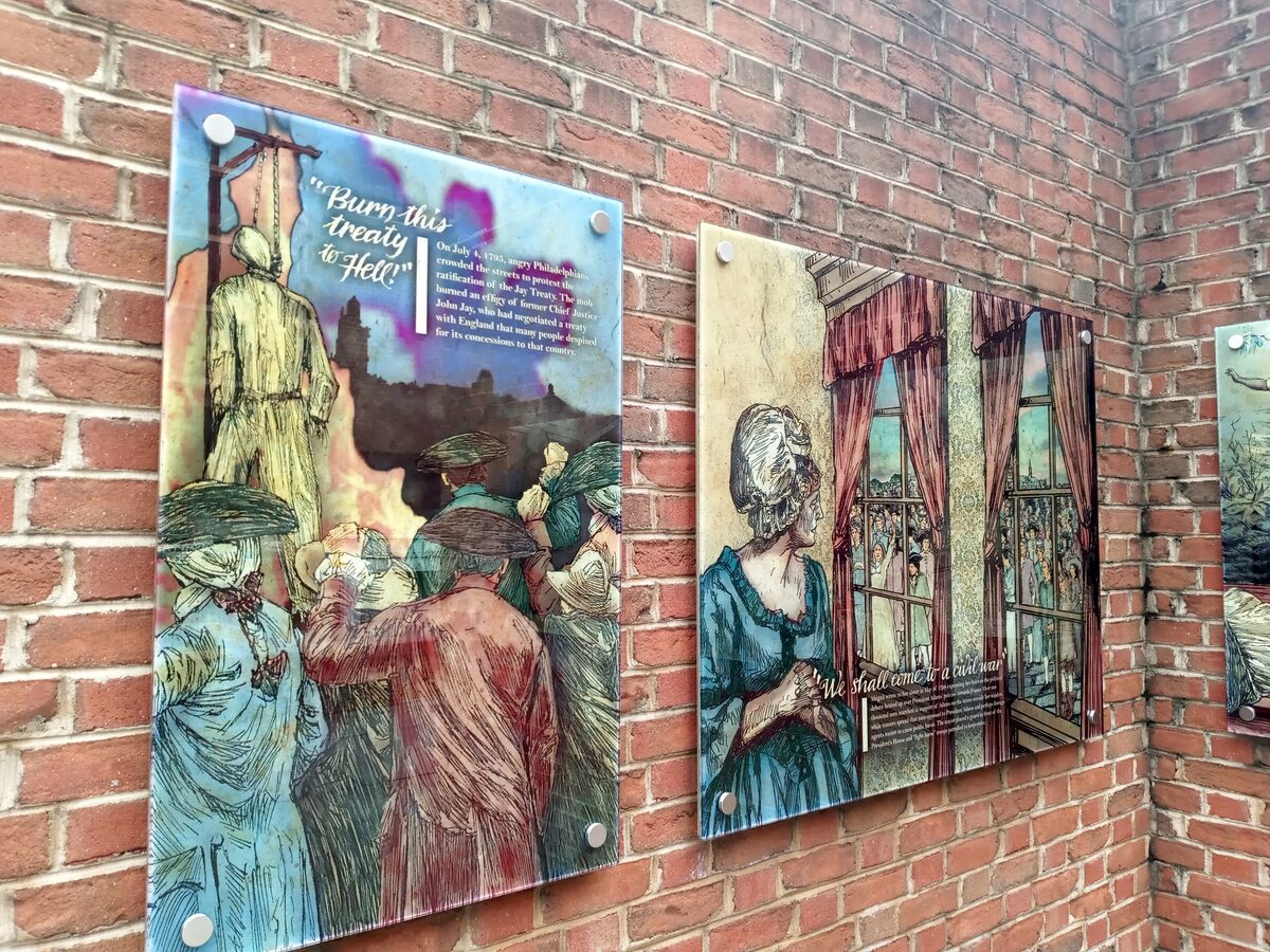 Illustrated exhibit panels about slavery mounted on the brick walls of the President's House Site