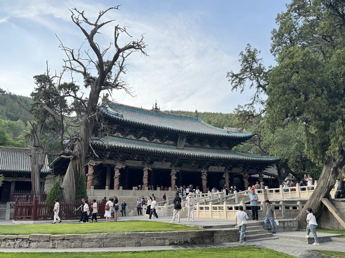 The double-eaved Hall of the Holy Mother at Jinci Temple behind old cypress trees and a white stone terrace