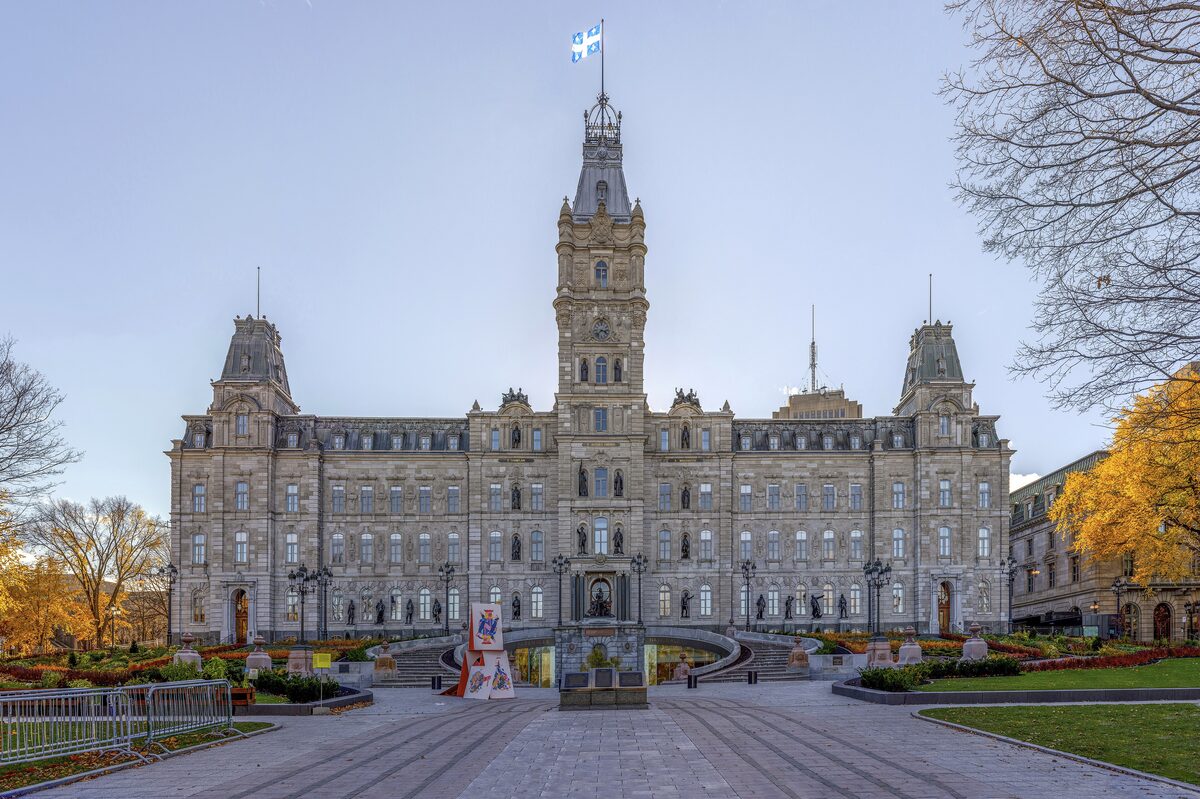 The Parliament Building of Quebec, a Second Empire facade with a central clock tower, seen across the gardens in autumn