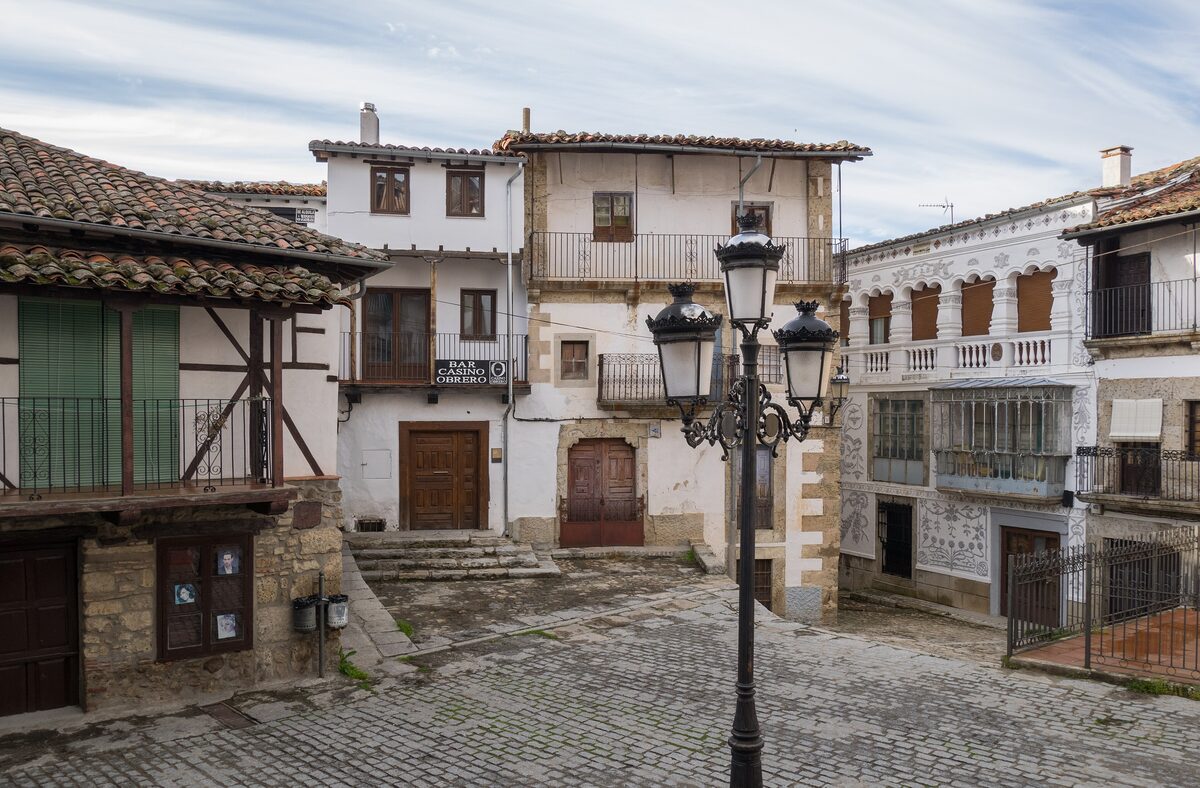 A square in Candelario with timber-framed houses and an iron street lamp