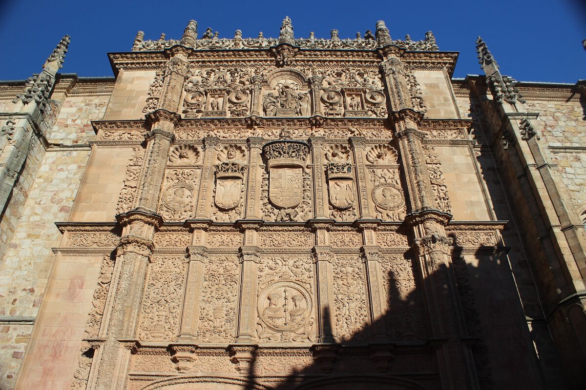 The plateresque facade of the University of Salamanca, crowded with carved shields and medallions