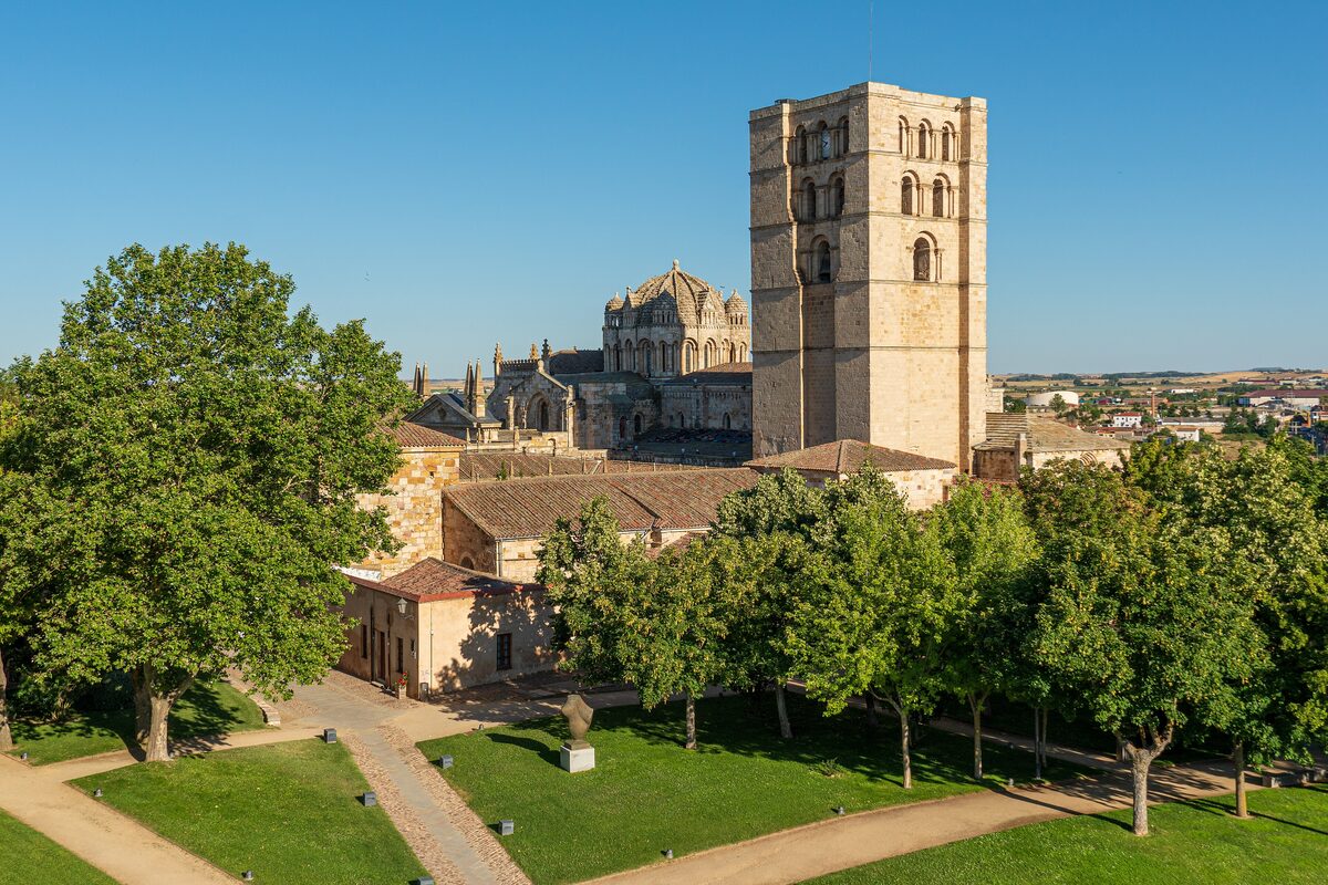 The tall Romanesque tower of Zamora Cathedral above trees and the old town
