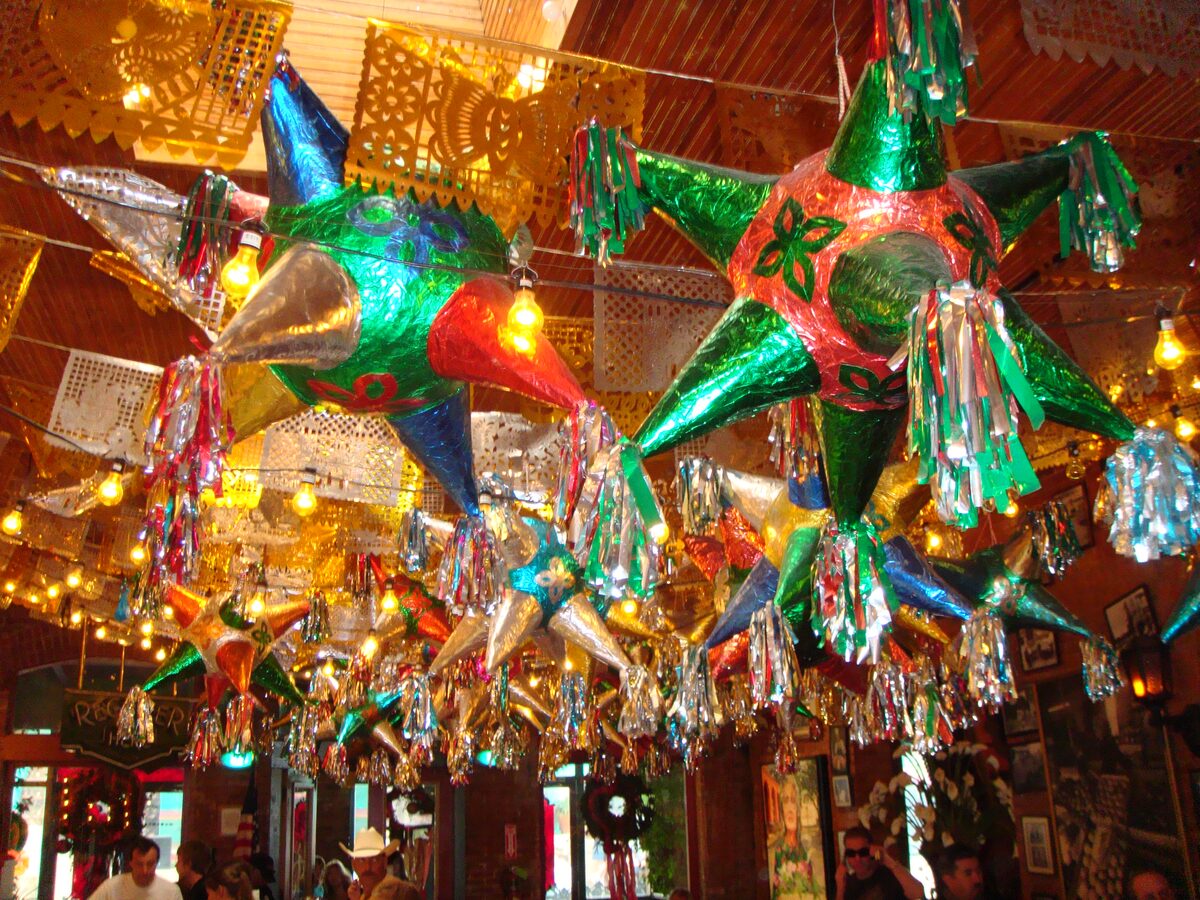 Glittering star piñatas and cut-paper banners hanging from the ceiling inside Mi Tierra