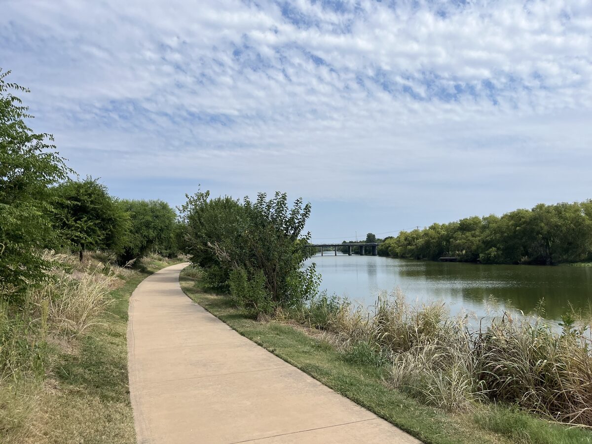 A concrete trail beside the San Antonio River on the Mission Reach