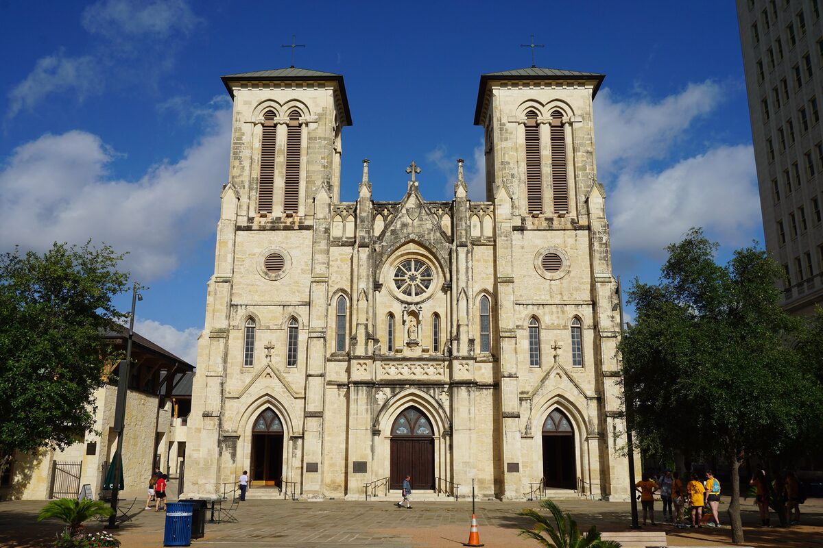 The twin-towered Gothic Revival facade of San Fernando Cathedral against a blue sky