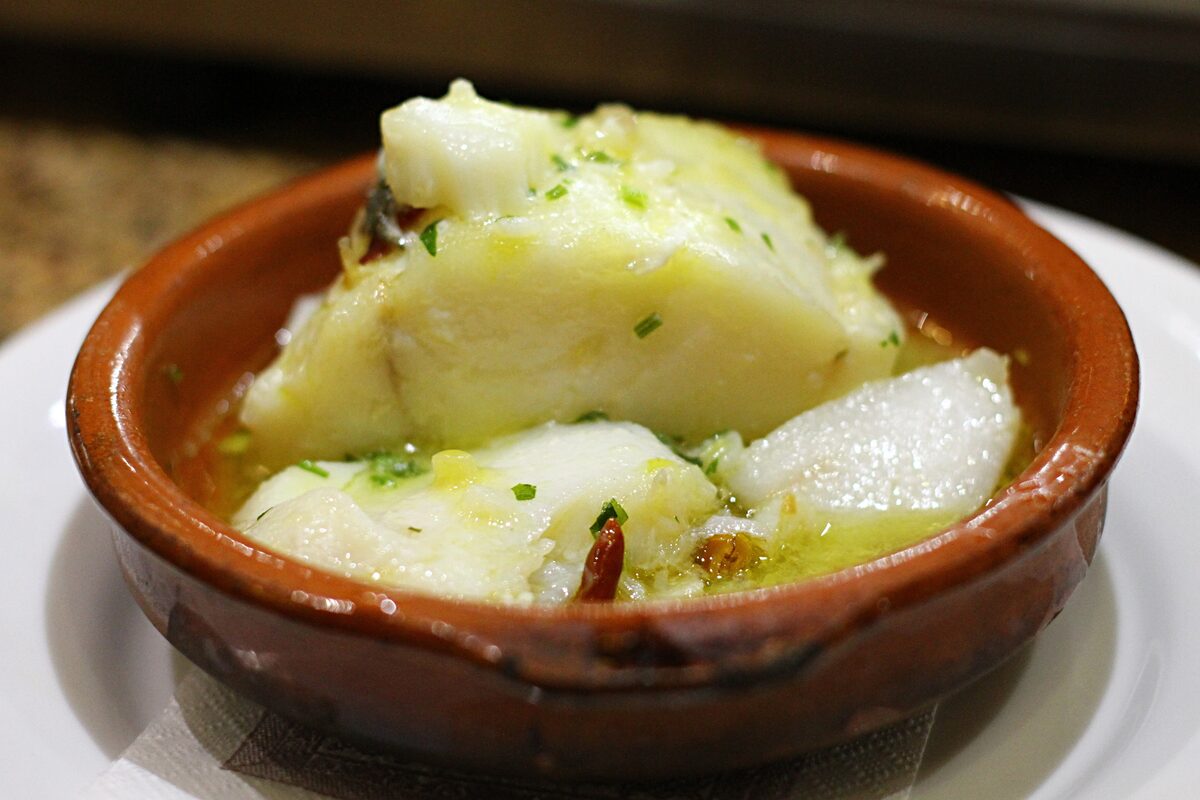 Salt cod with garlic, oil and chili served in a clay dish, bacalao al pil-pil