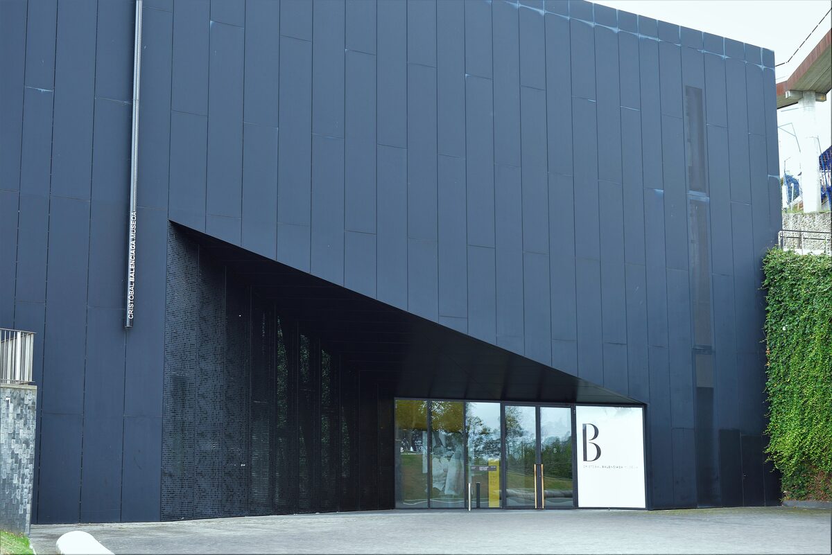 The dark grey Cristóbal Balenciaga Museum building in Getaria, its name running down one corner and a large B on the glass entrance