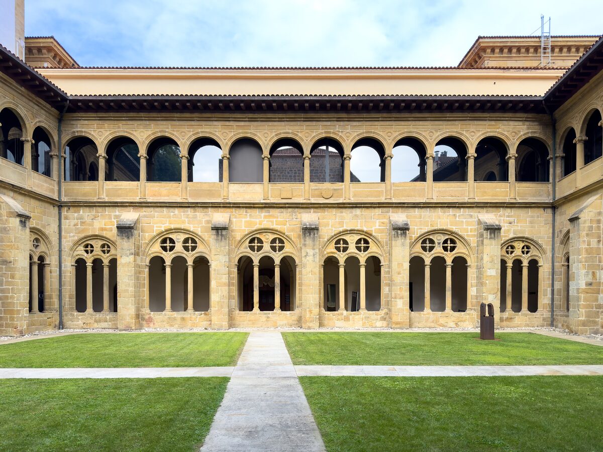 The cloister of the San Telmo Museum: a square courtyard of lawn, with stone arches and a gallery around it
