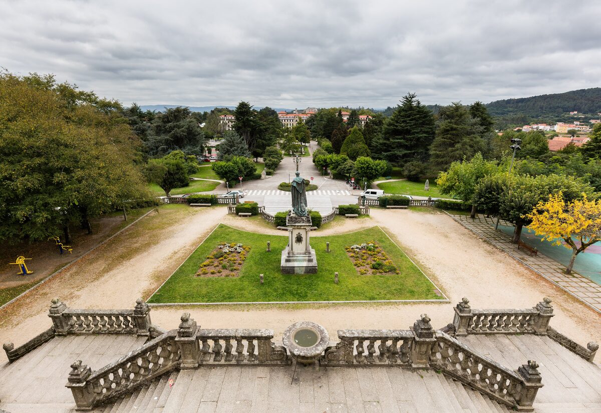 The Alameda park seen from its stone steps, with a statue on a flowered lawn among the trees