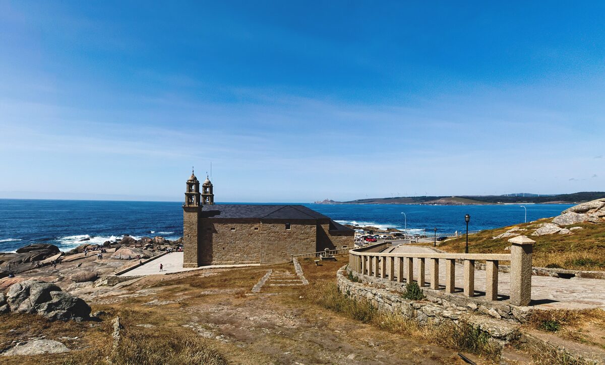 The Santuario da Virxe da Barca on its rocky headland at Muxía, with the Atlantic beyond