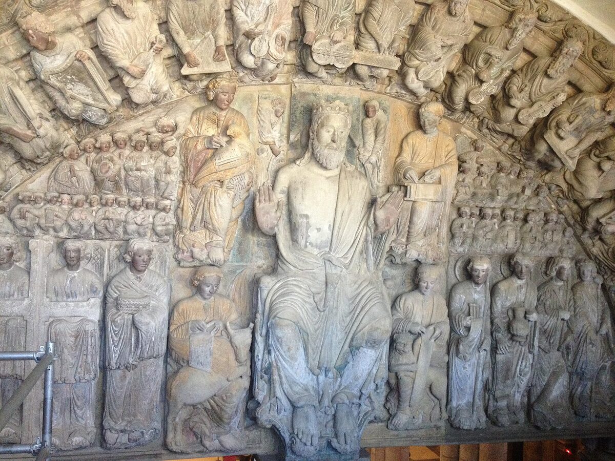 The central arch of the Pórtico da Gloria, with a crowned Christ raising his hand in blessing among rows of carved saints
