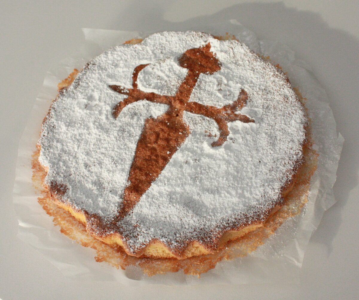 A Tarta de Santiago dusted with icing sugar, with the cross of Saint James stenciled on top