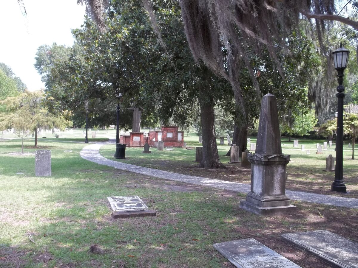 Obelisk and flat graves under Spanish moss in Colonial Park