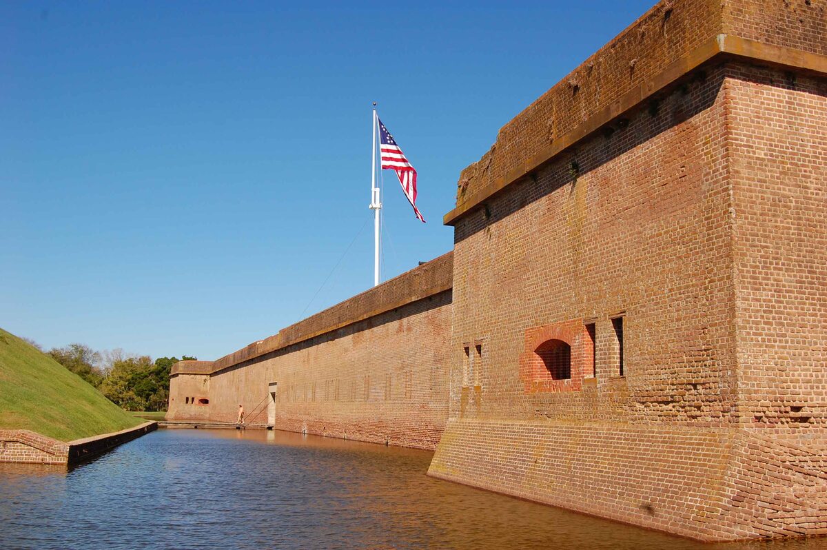 Brick wall and moat of Fort Pulaski under a blue sky