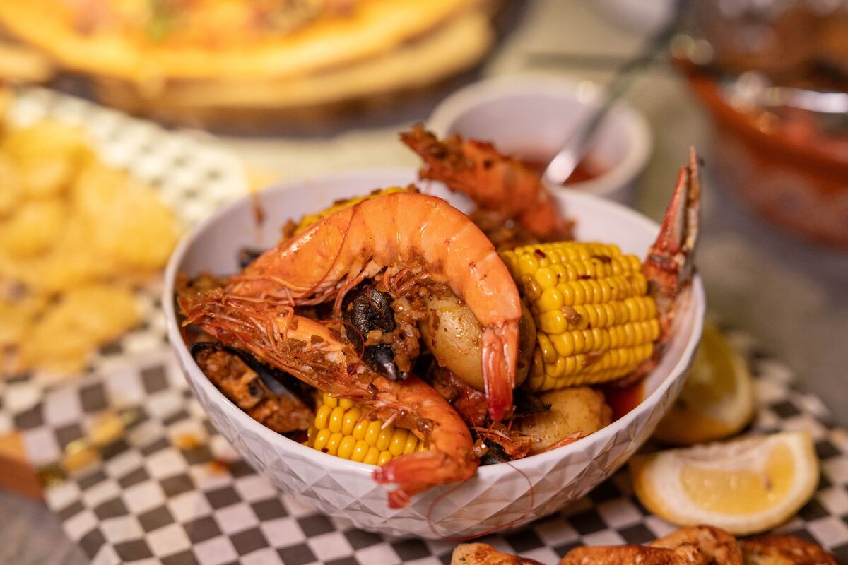 Boiled shrimp, corn and lemon in a bowl, boil style