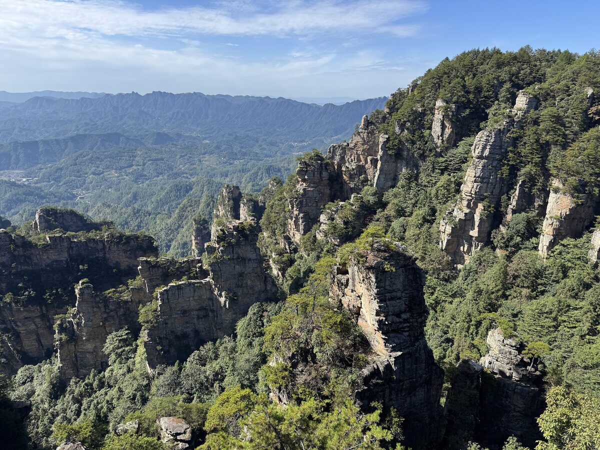 A ridge of sandstone pillars and forested slopes seen from the Natural Great Wall viewpoint in the Yangjiajie area
