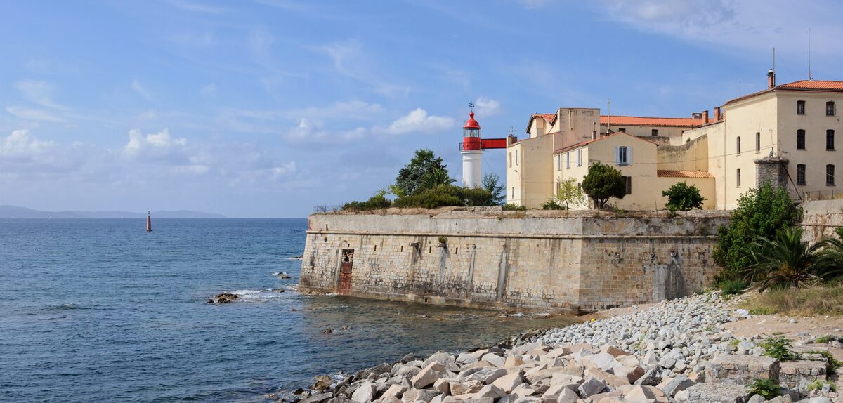The citadel walls and the lighthouse on its rocky point above the sea, with the town beyond